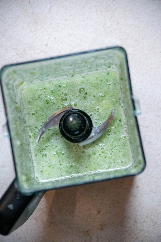 add cucumbers, whole cut limes, the juice of one lemon, the gin, and simple syrup to the blender, and blend on high speed until smooth and liquid. 