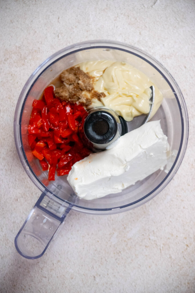 add softened cream cheese, mayonnaise, drained pimentos, Worcestershire sauce, and prepared horseradish to your food processor with the blade in place. 