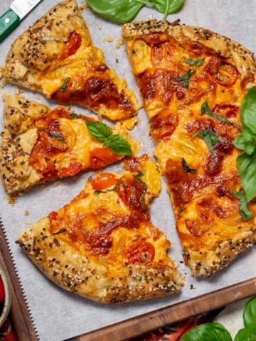 Tomato Galette with Pimento Cheese and Cheddar cut on a board with basil