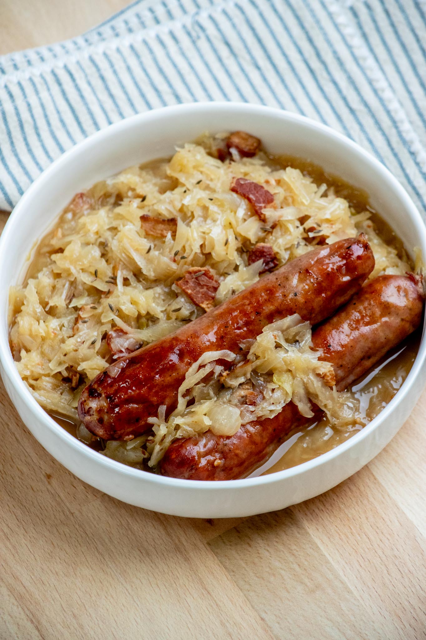 Bowl of beer bacon and caraway seed sauerkraut with a side of bratwurst, 