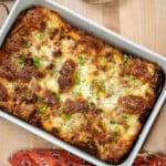 Overhead view of croissant breakfast casserole with sausage, leeks and melted Gruyère cheese.