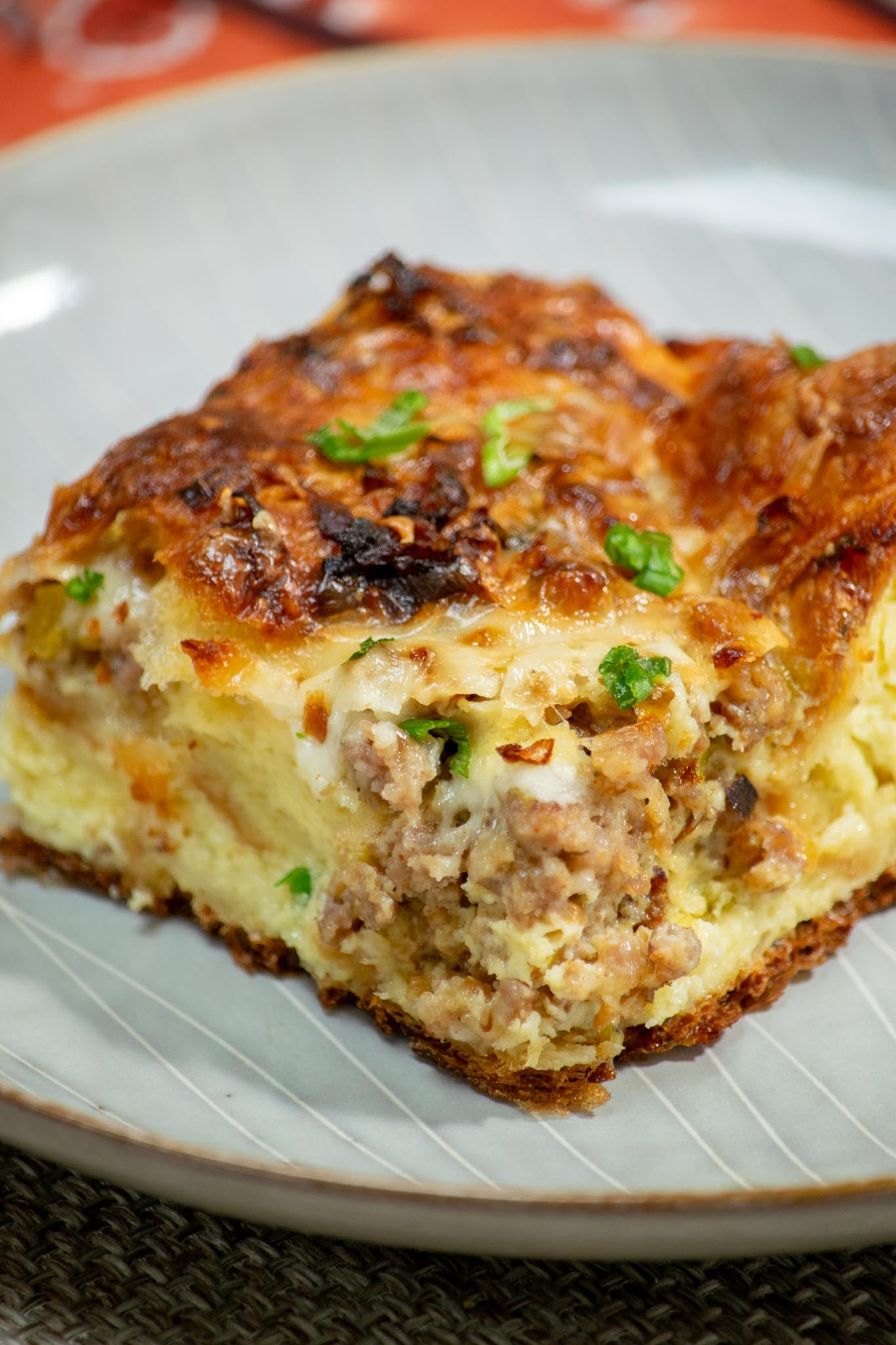 Croissant breakfast casserole with sausage, leeks and Gruyère on a plate.