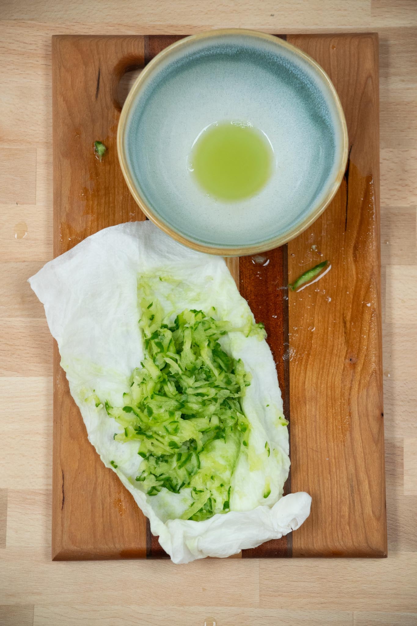 Using s clean kitchen towel or paper towels, wring out the excess liquid from the cucumber and discard.