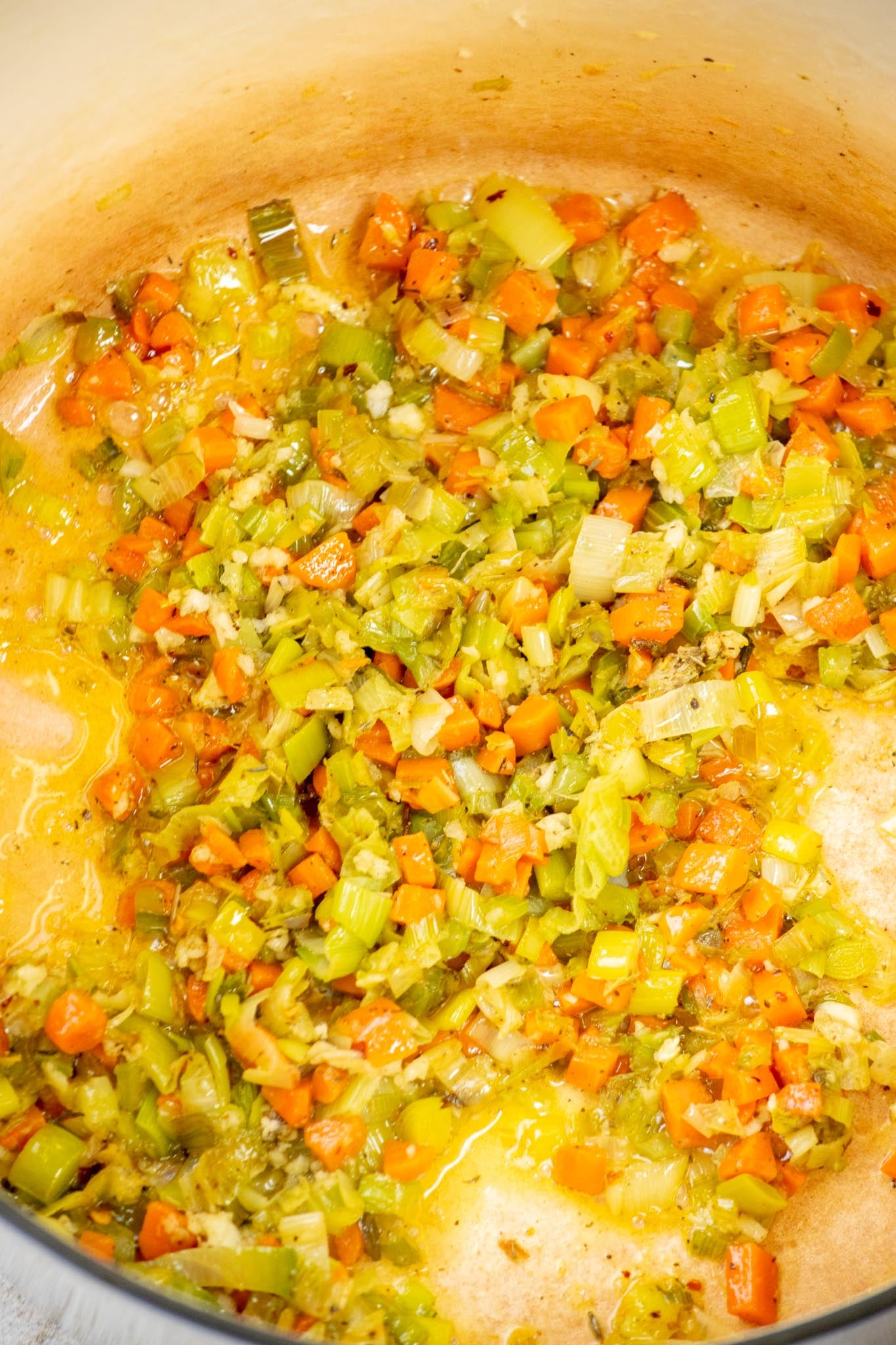 Add the aromatics. Stir in the thyme, poultry seasoning, crushed red pepper flakes, and garlic. Cook for about 1 minute, until fragrant.