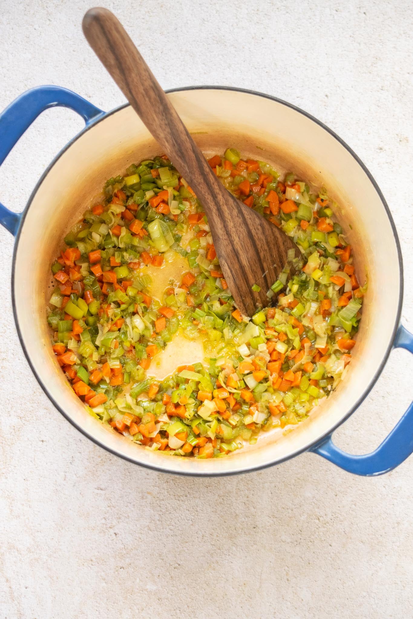 Sauté the vegetables. Melt the butter with the olive oil in a large stock pot or Dutch oven over medium heat. Add the carrots, celery, and leeks, season with salt and pepper, and cook for 8–10 minutes, until softened.