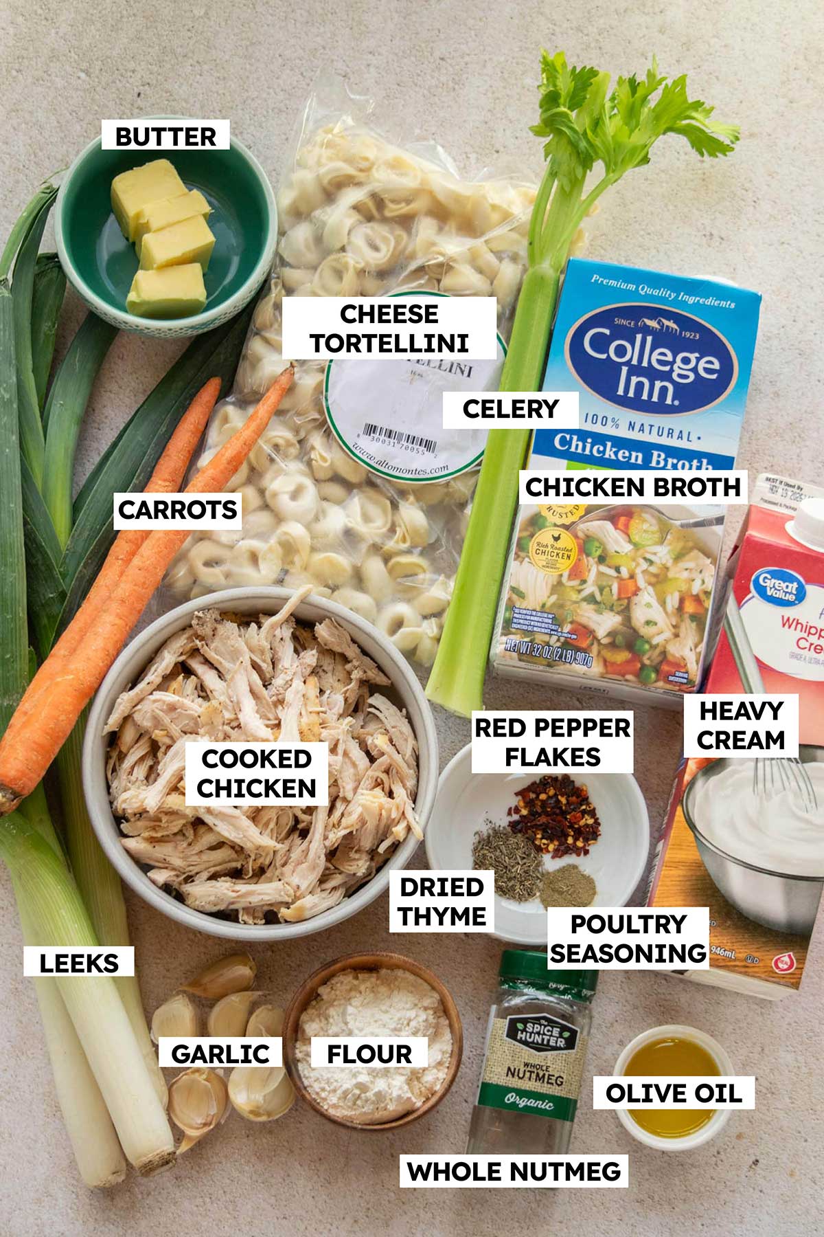 Ingredients for creamy chicken tortellini soup with leeks, including shredded chicken, cheese tortellini, leeks, carrots, celery, chicken broth, cream, and seasonings.