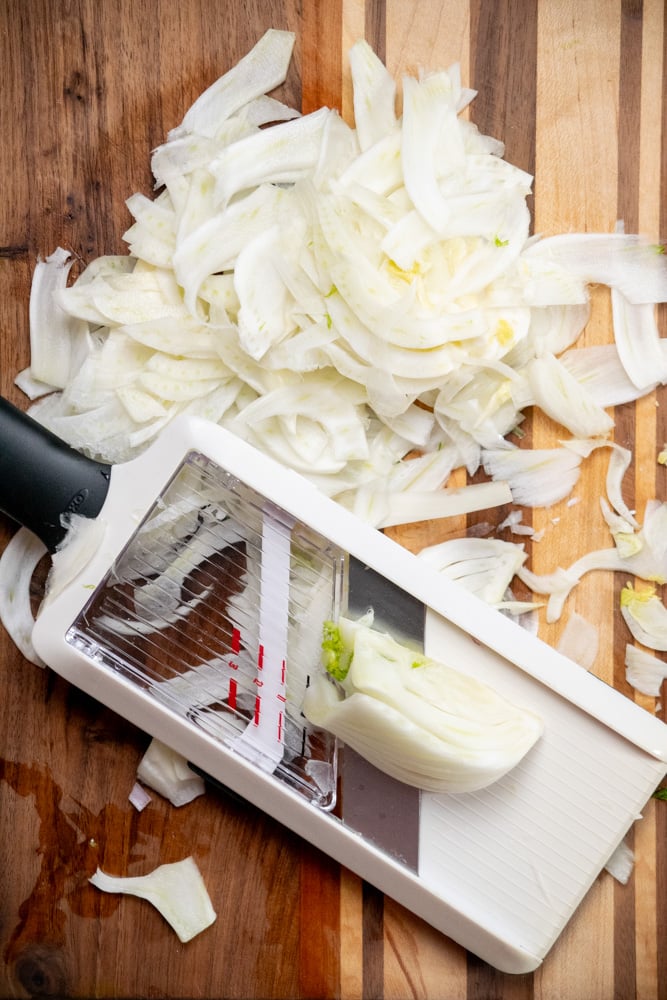 thinly shave the fennel using a mandoline slicer, you can do this lengthwise or crosswise for thinner or wider pieces 