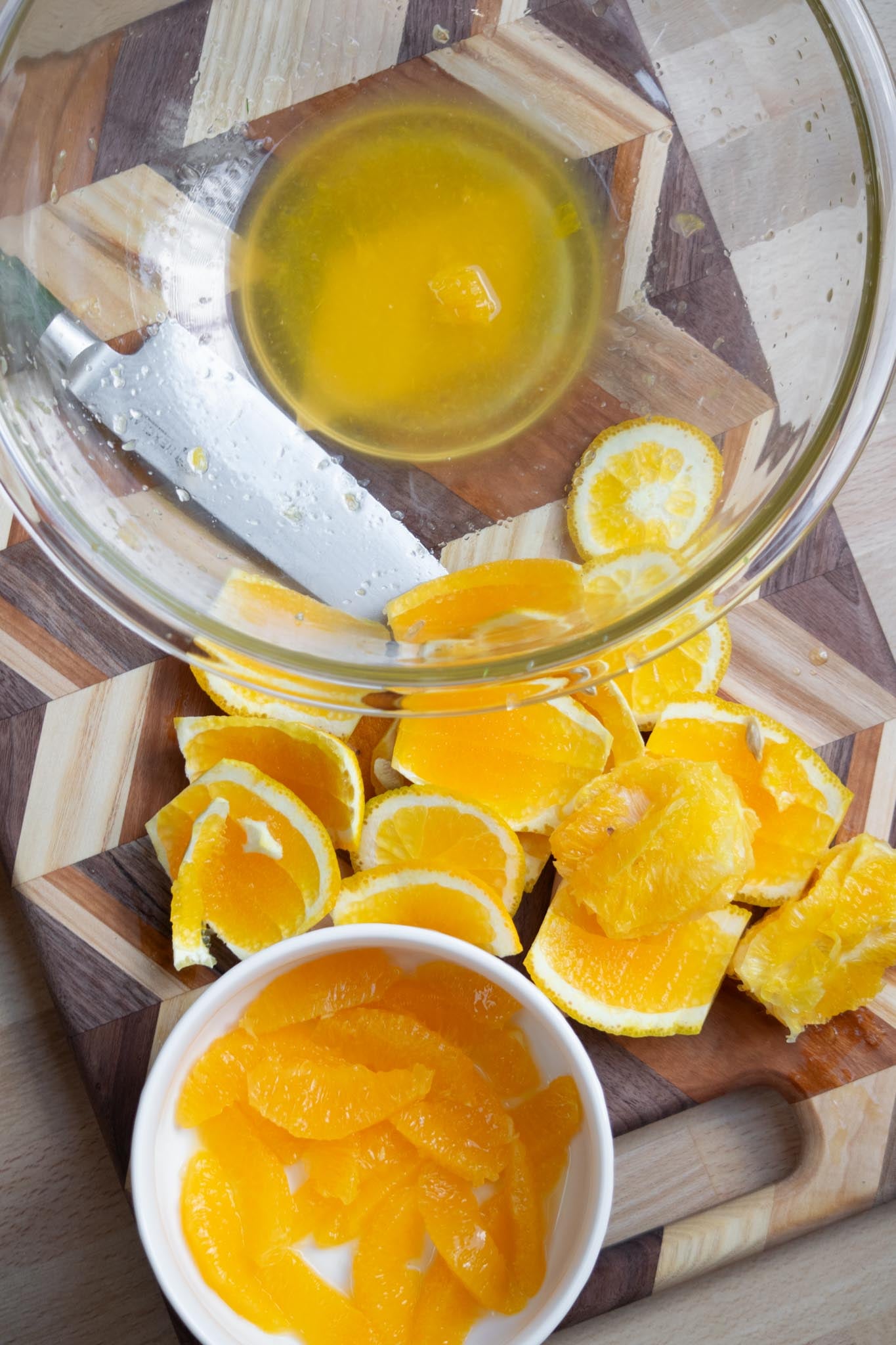 Peel the oranges, and cut into segments over a large bowl, reserving the juice.