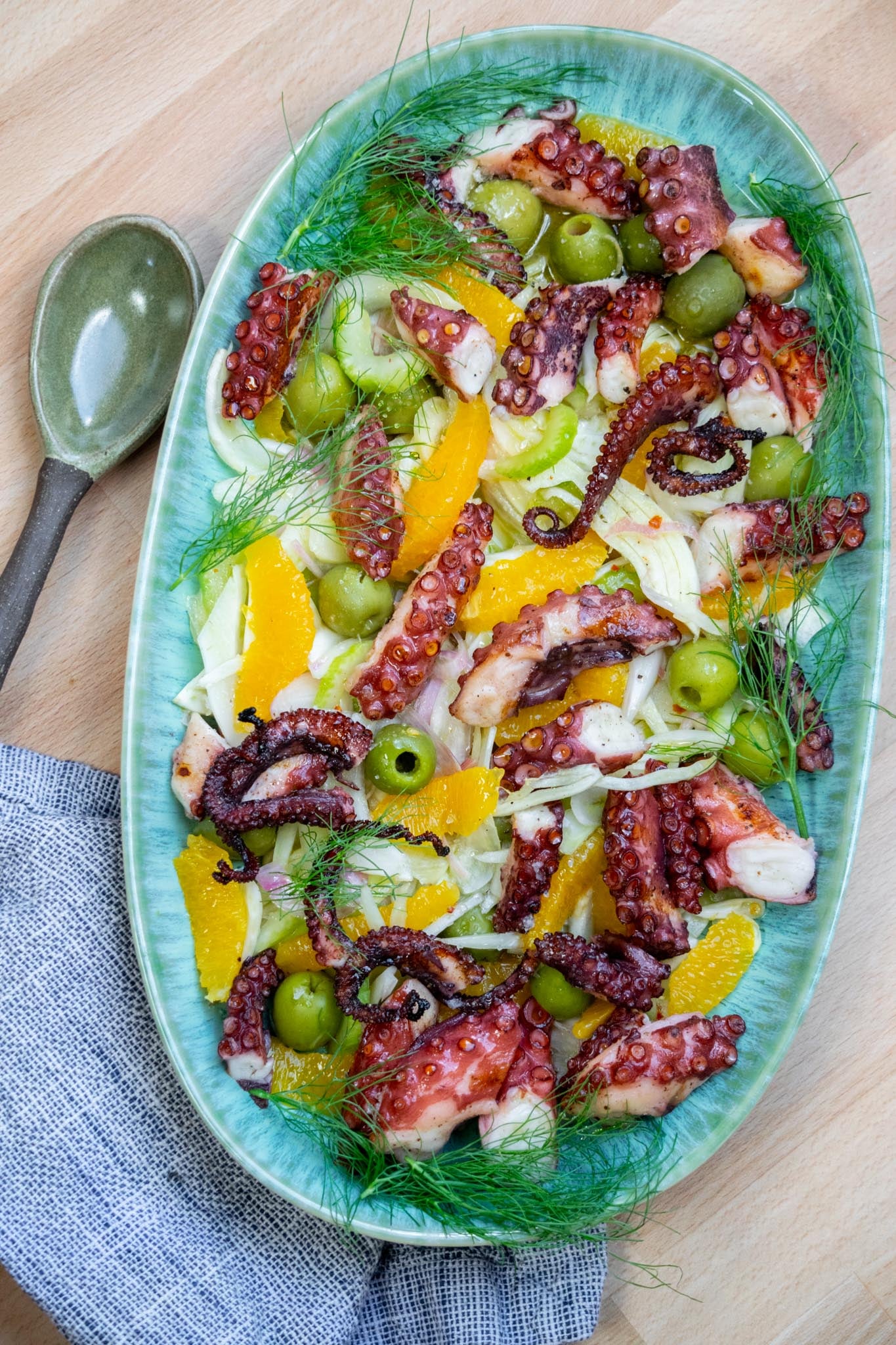 Octopus Salad Recipe with Grilled Octopus, Fennel & Olives on a platter with fennel fronds as garnish.