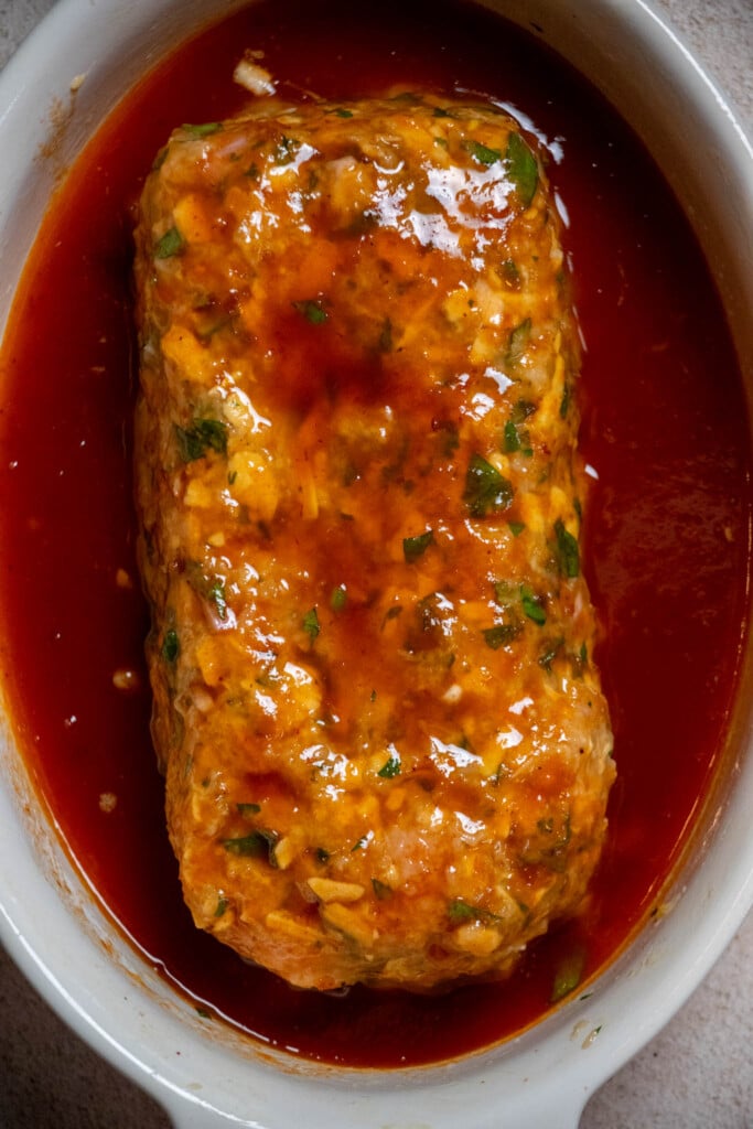 pour the glaze over the meatloaf, and use a basting brush to evenly coat the loaf with the excess from the sides of the pan so it's well coated. 