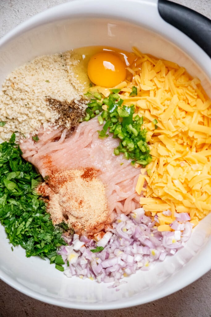 add ground chicken, shredded cheddar, panko breadcrumbs, diced jalapeno, shallots, cilantro, spices, Worcestershire sauce and egg to a large bowl. 