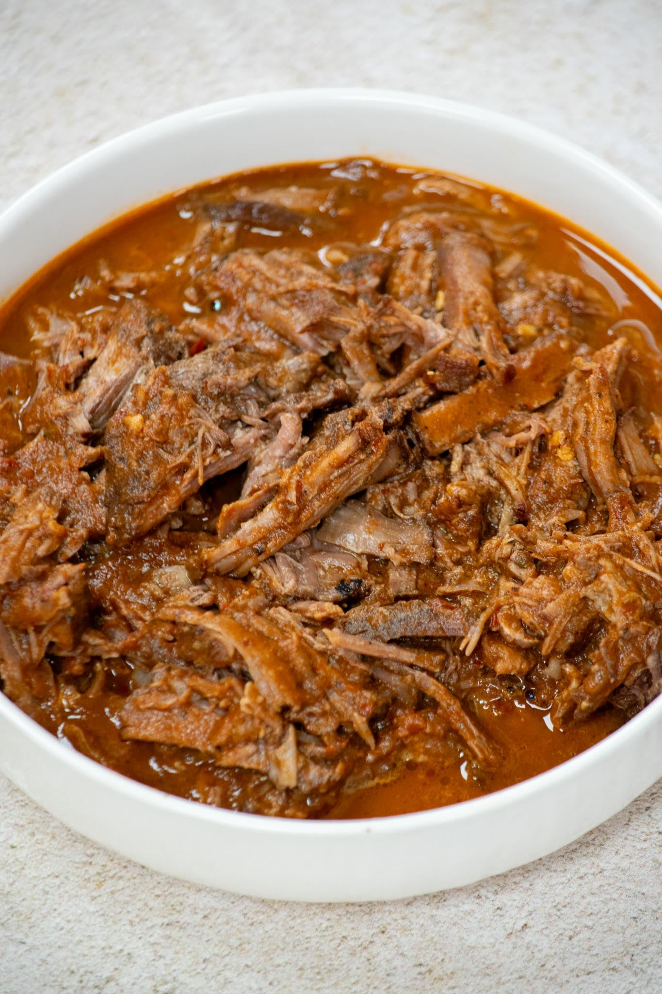 Sauce your shredded beef. Ladle a bit of strained or blended consommé over the beef, and toss to combine.