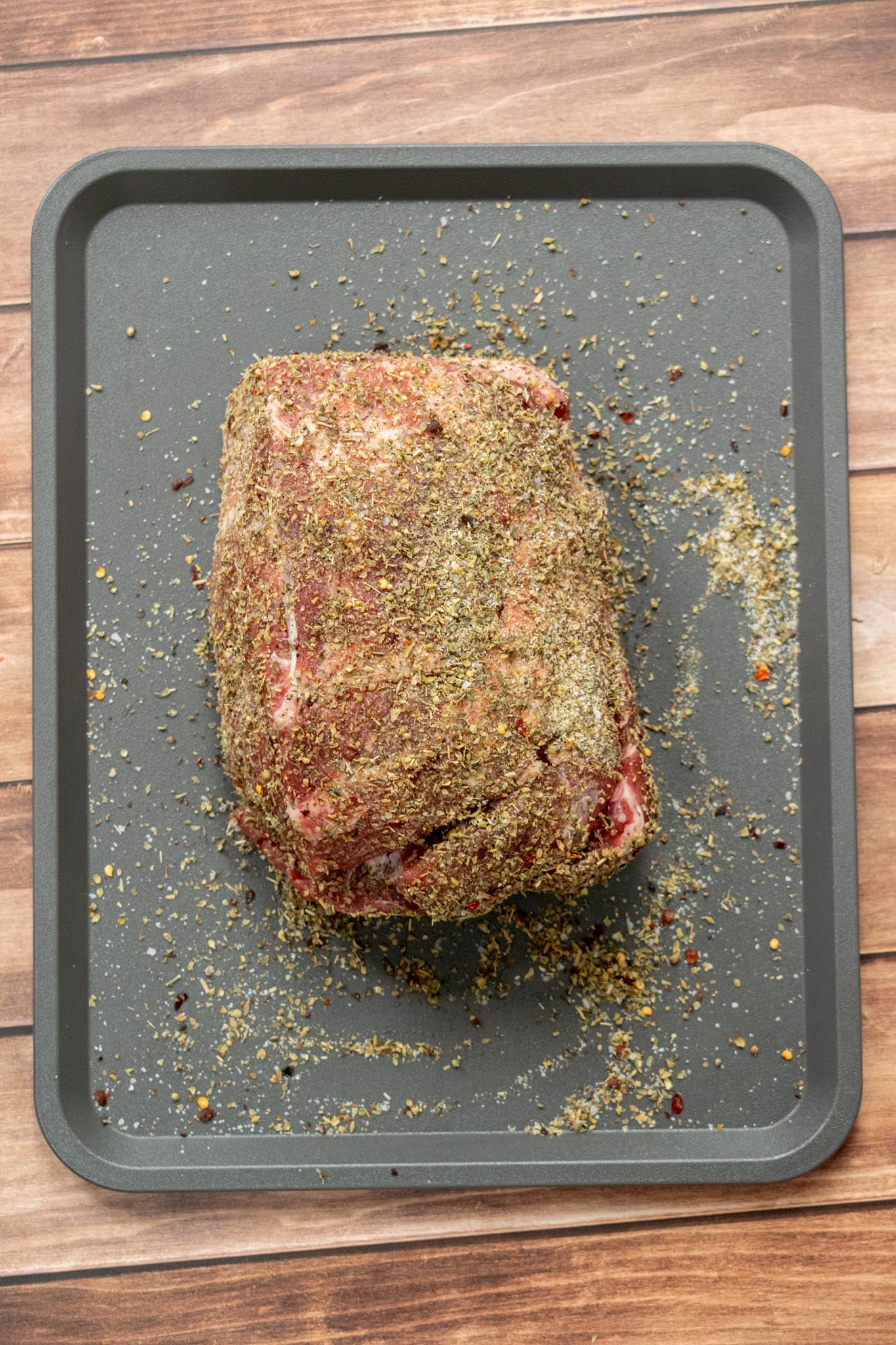 Prepare and season the pork. If your pork shoulder doesn't fit comfortably in the slow cooker, cut it into a few large pieces. No need to get fancy. We just want everyone in the pool. Combine the spice rub ingredients and coat every inch of the pork, then place it over the onions, garlic, and wine, fat side up where possible.