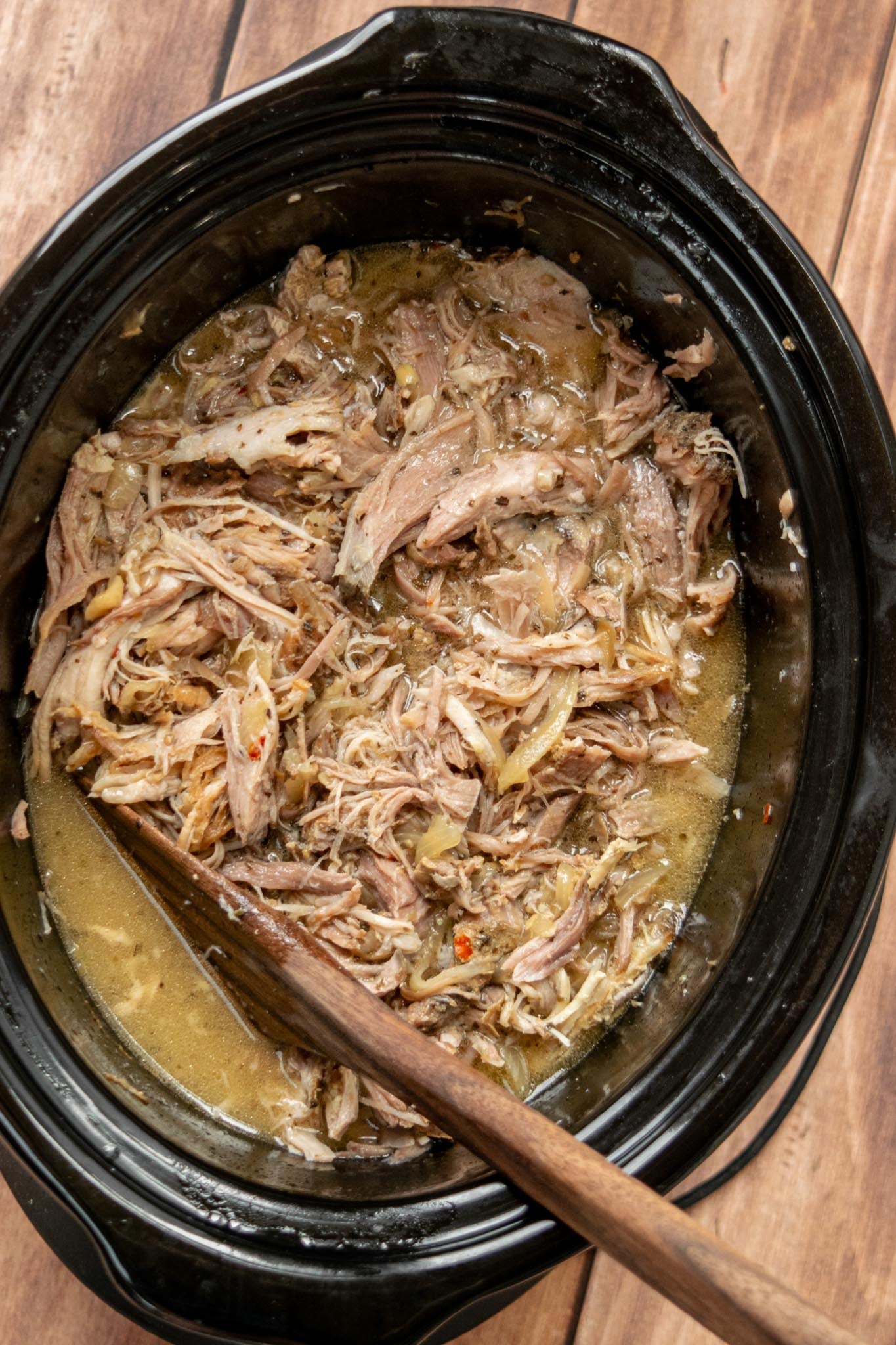 Return the pork to the slow cooker. Skim excess fat from the cooking juices, then add the shredded pork back to the crockpot and toss to coat. Let it soak up all those delicious juices before serving.