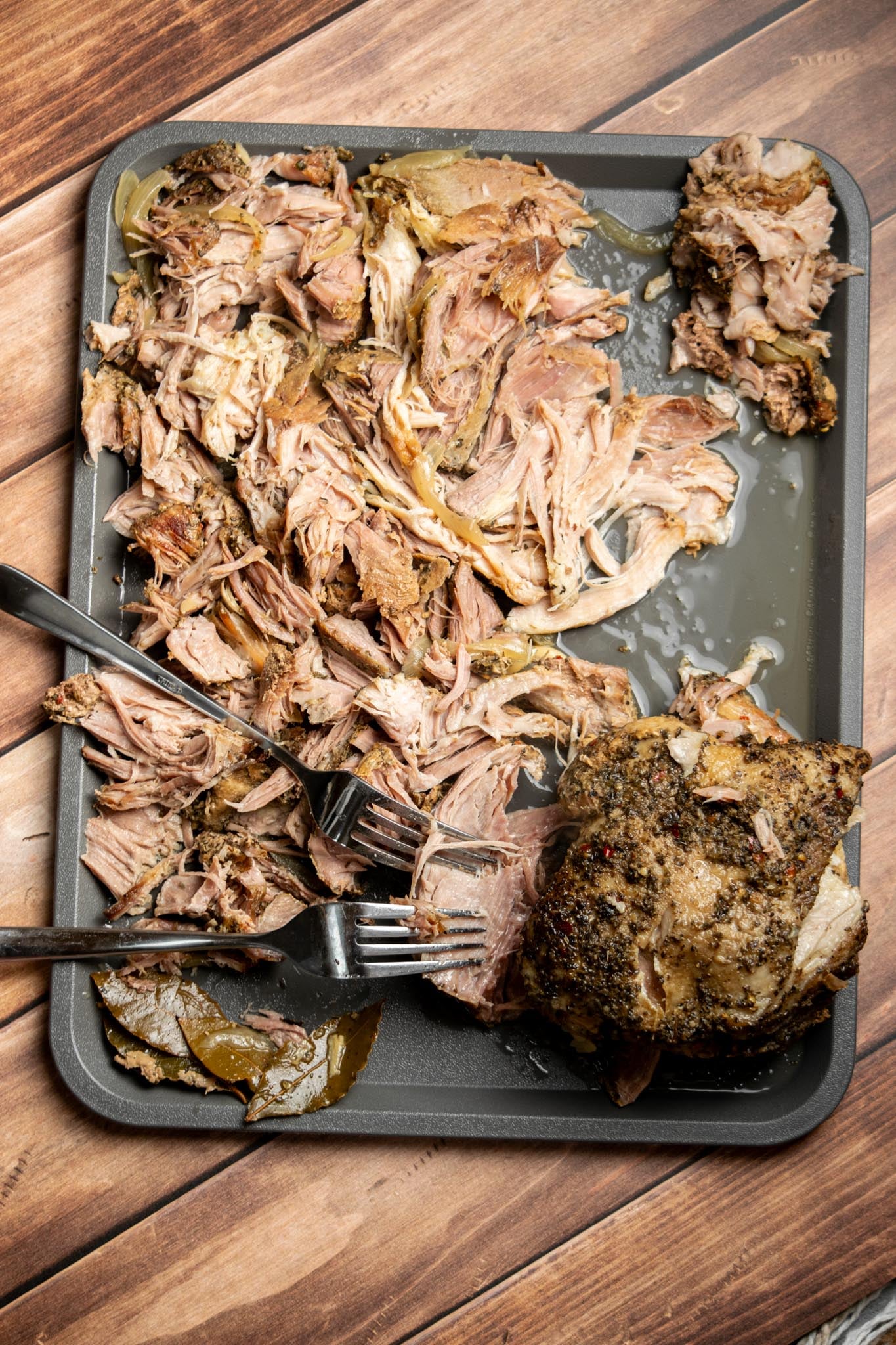 Shred the pork. Remove the pork from the slow cooker and discard the bones and excess fat. Use two forks to shred the meat into bite-sized pieces.