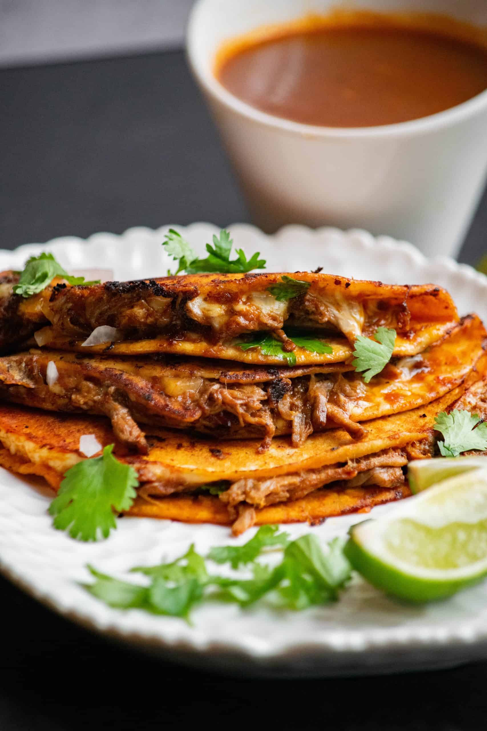 crockpot birria tacos on plate with dip