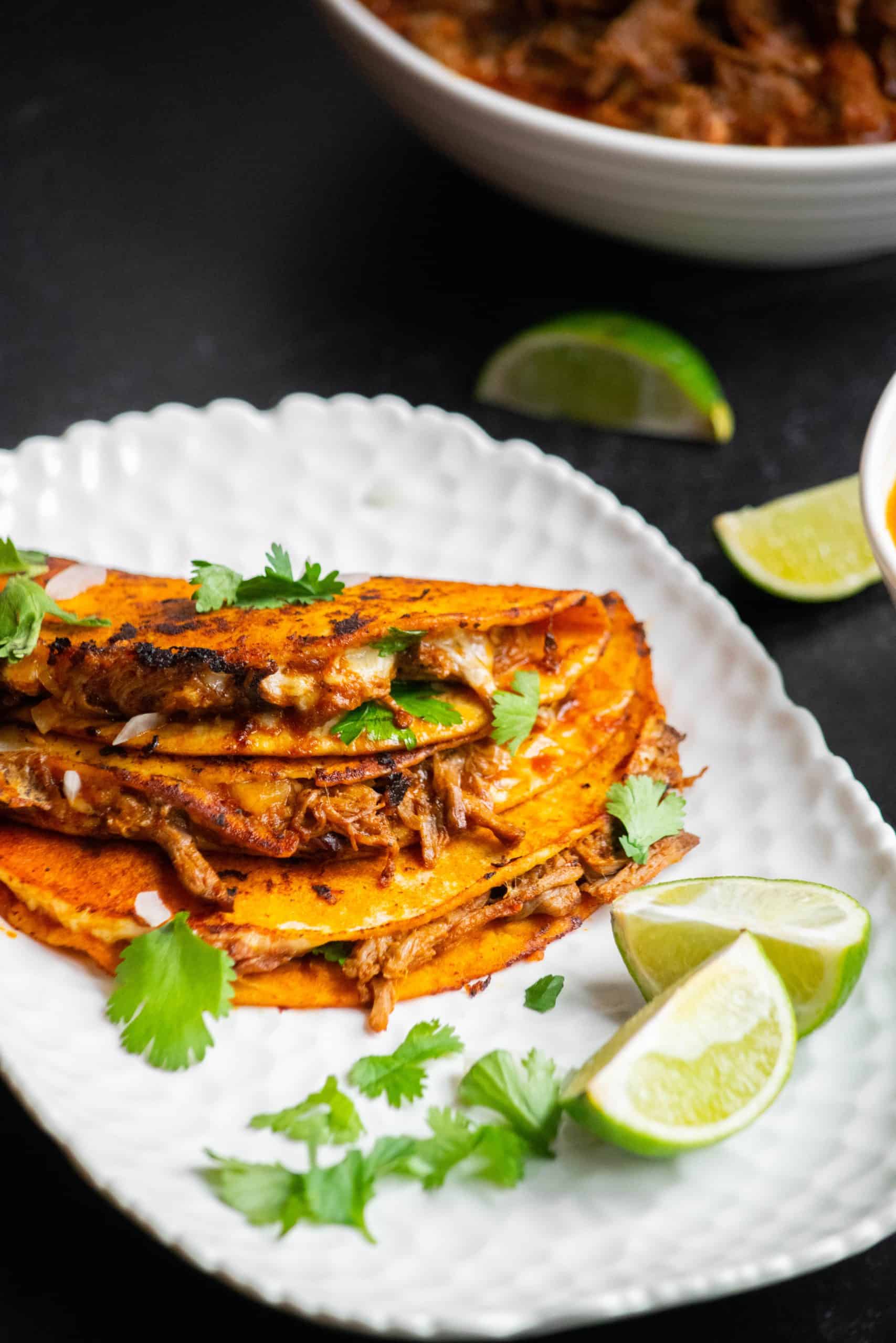crockpot birria tacos plated with lime