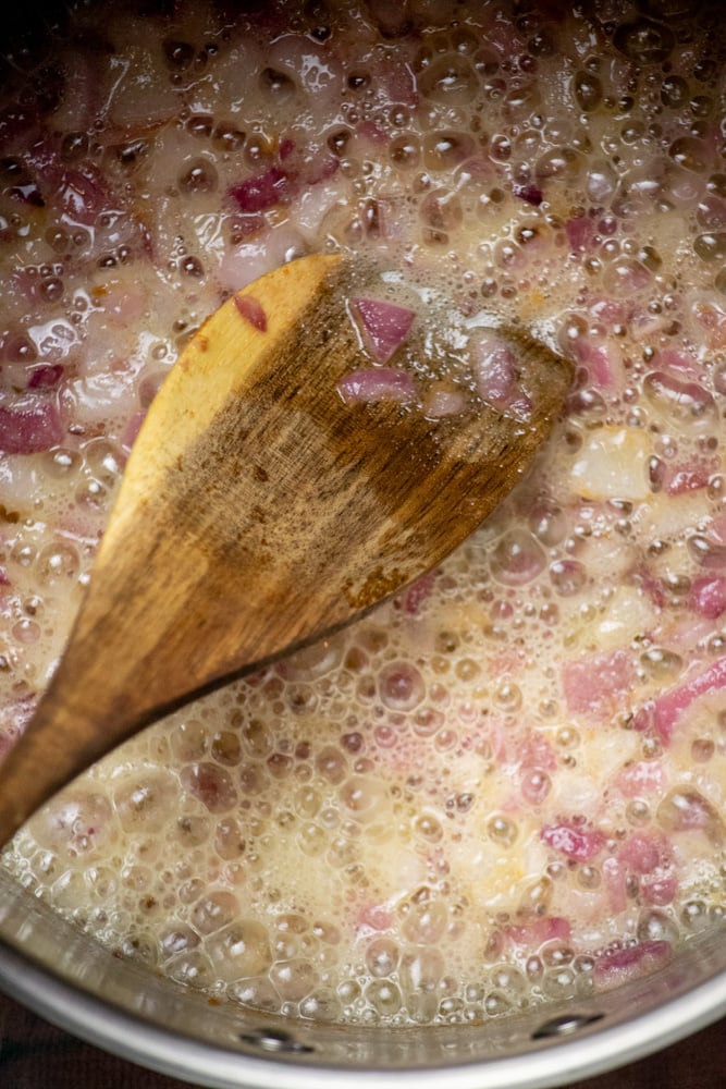 Cook garlic and onions in butter, then add flour