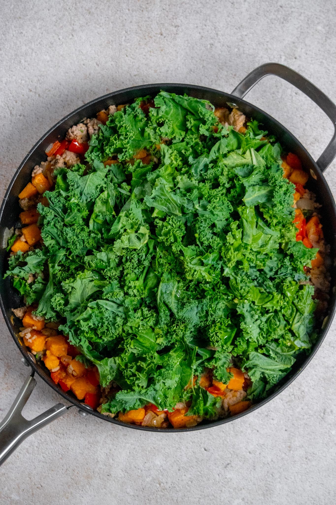 Add the kale. Stir the turkey and vegetables together, then add the chopped kale and chicken stock. Reduce the heat to low, cover, and cook for 5–7 minutes, stirring occasionally, until the kale is tender and wilted.