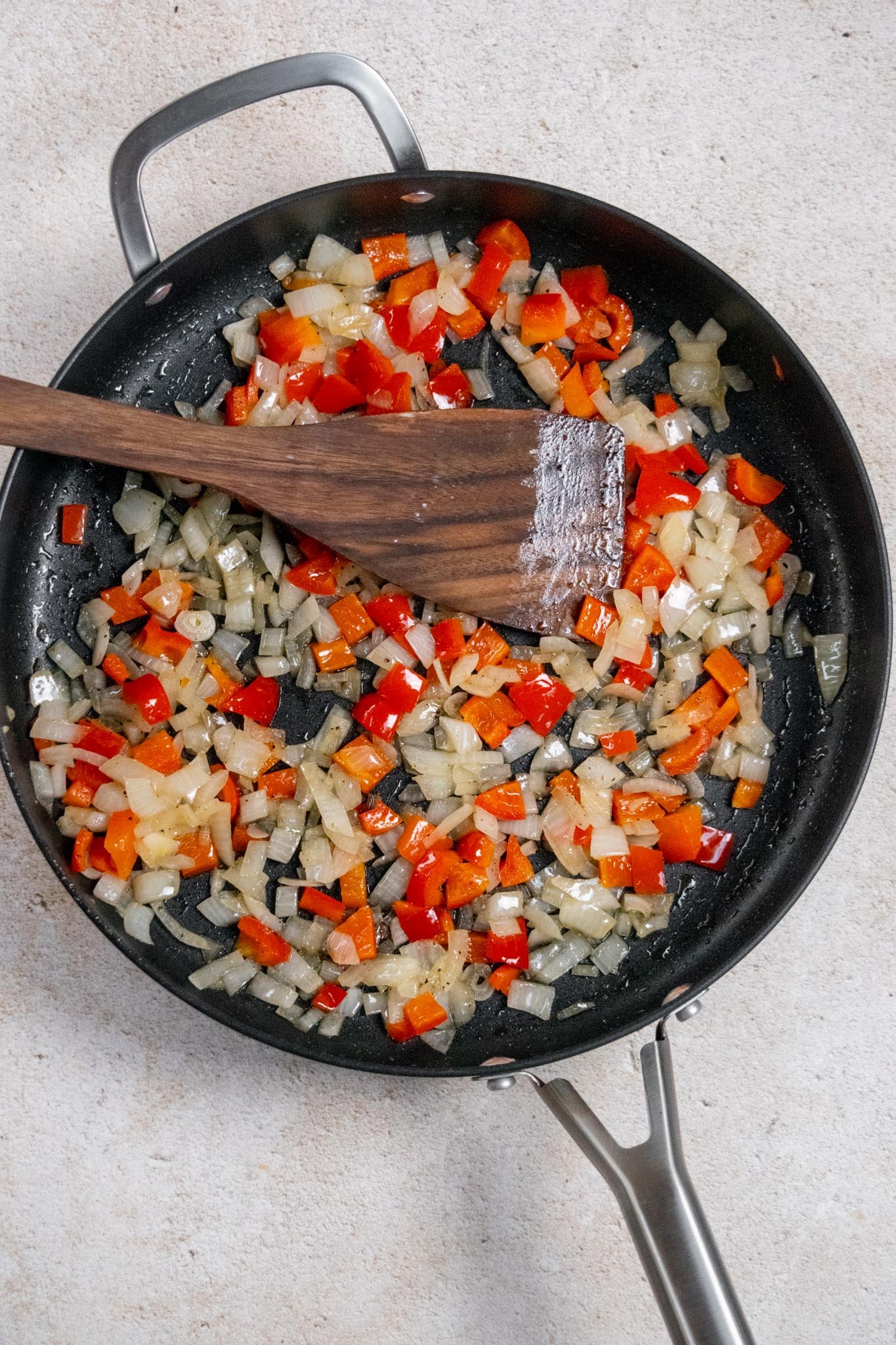 Cook the peppers and onions. While the sweet potatoes cook, heat the olive oil in a large, deep skillet over medium heat. Add the peppers and onions, season with salt and pepper, and cook for about 5 minutes, stirring occasionally, until they begin to soften.