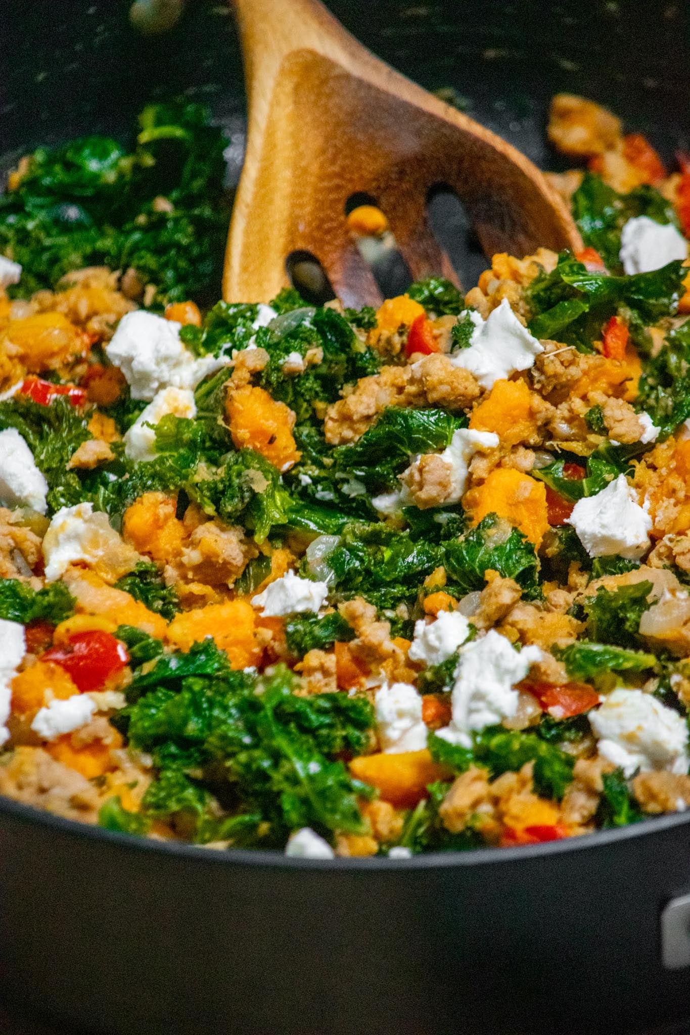Close-up of ground turkey skillet with sweet potatoes, kale, red peppers and crumbled goat cheese.