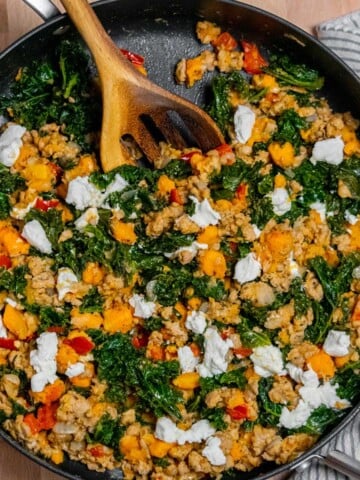 Ground turkey skillet meal with sweet potatoes, kale and goat cheese in a large skillet.
