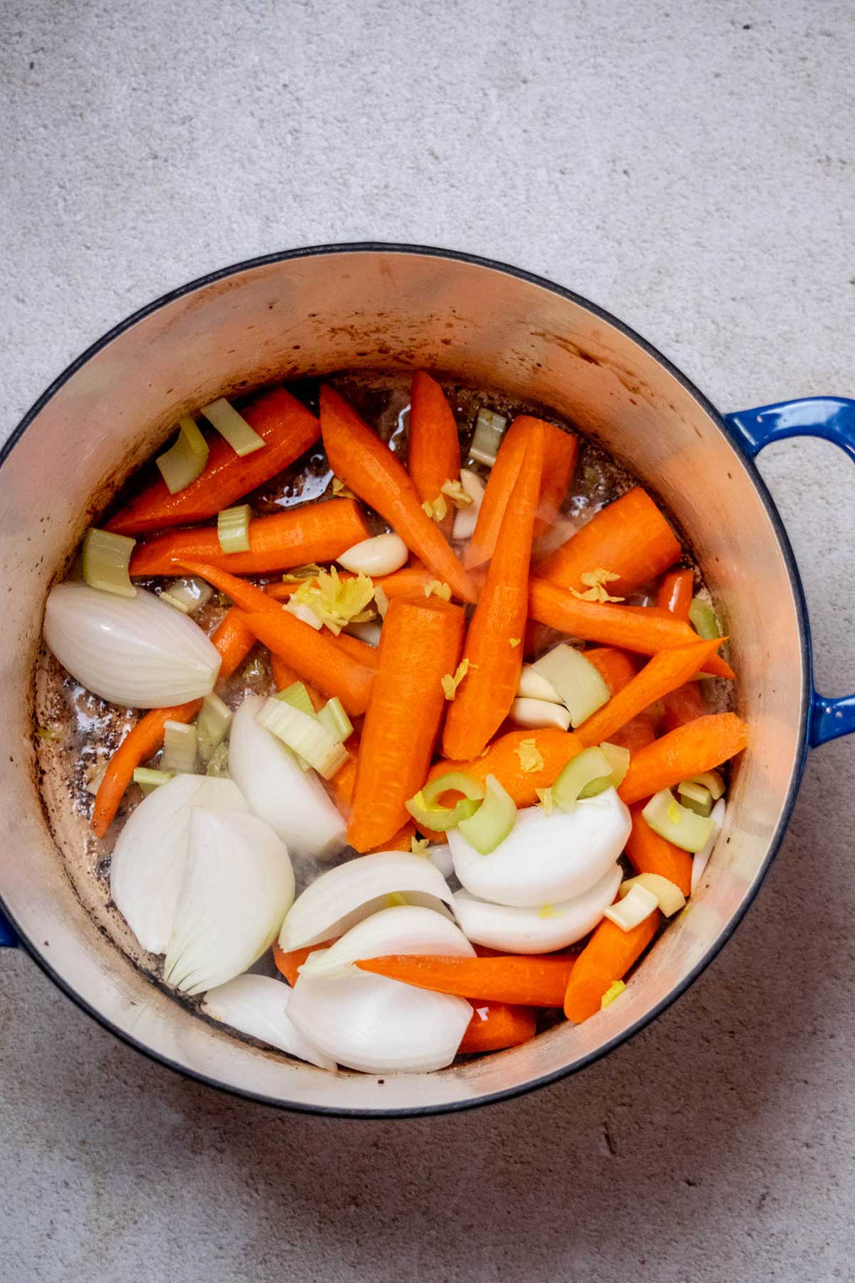 Add the vegetables and garlic to the Dutch oven and cook for 2–3 minutes, stirring occasionally, until they begin to take on some color.