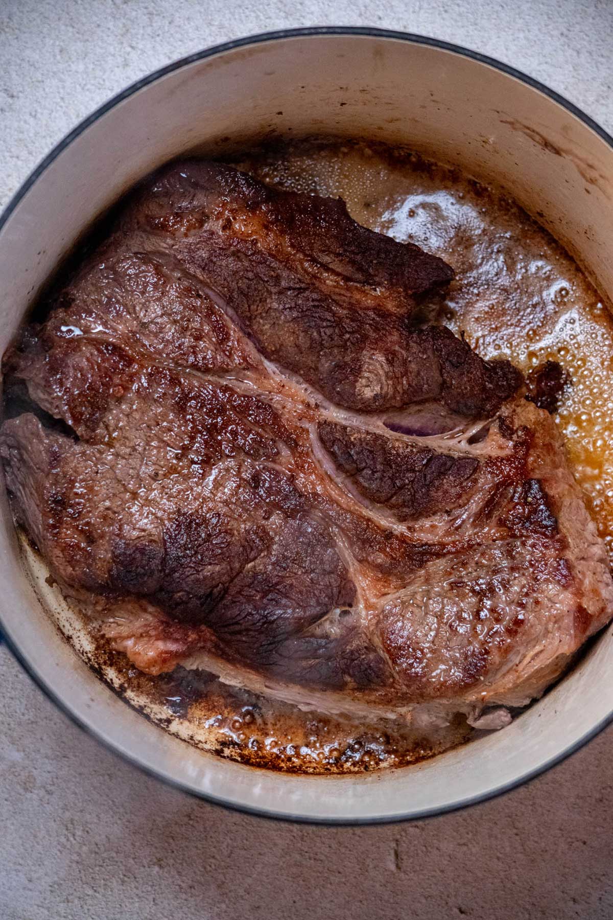 Sear the beef in a hot Dutch oven with the oil and butter for 4–6 minutes per side, until deeply browned and a crust forms. Transfer the seared roast to a plate and set aside.