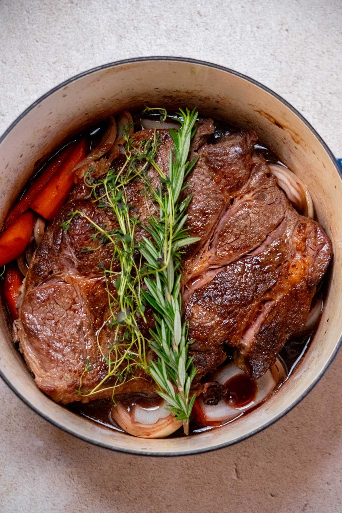 Return the beef to the Dutch oven along with any accumulated juices, then top with the fresh rosemary and thyme.