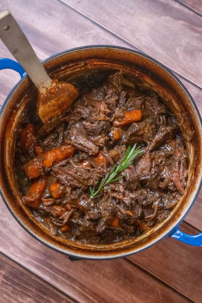 Return the shredded beef to the pot, and toss to coat in the braising liquid/gravy. 