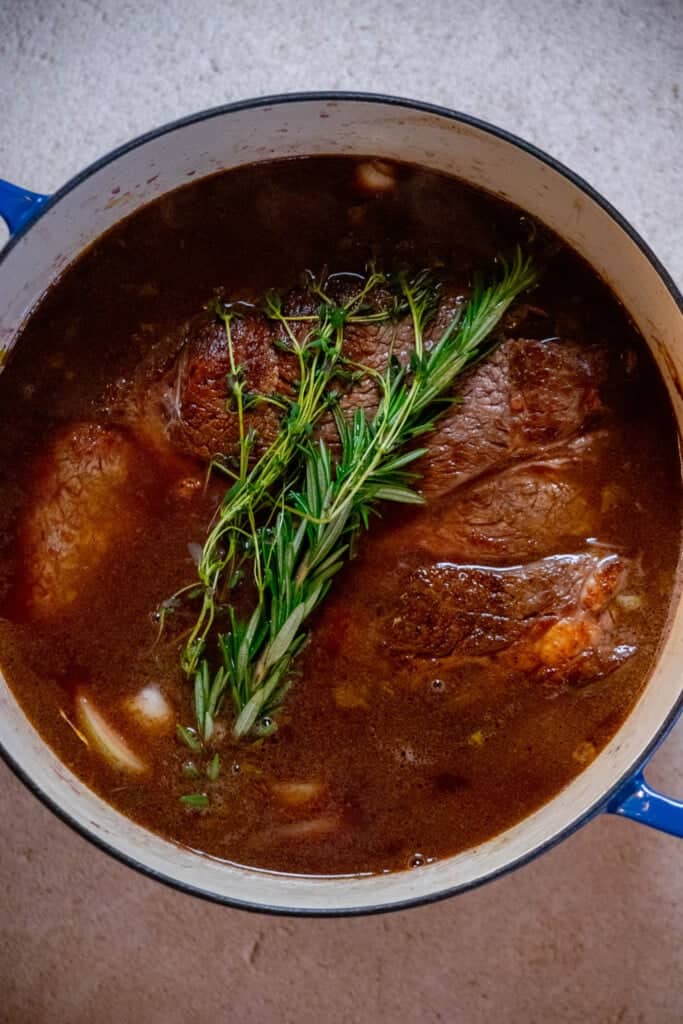 Cover with beef stock, and transfer to preheated oven for 3 hours. 