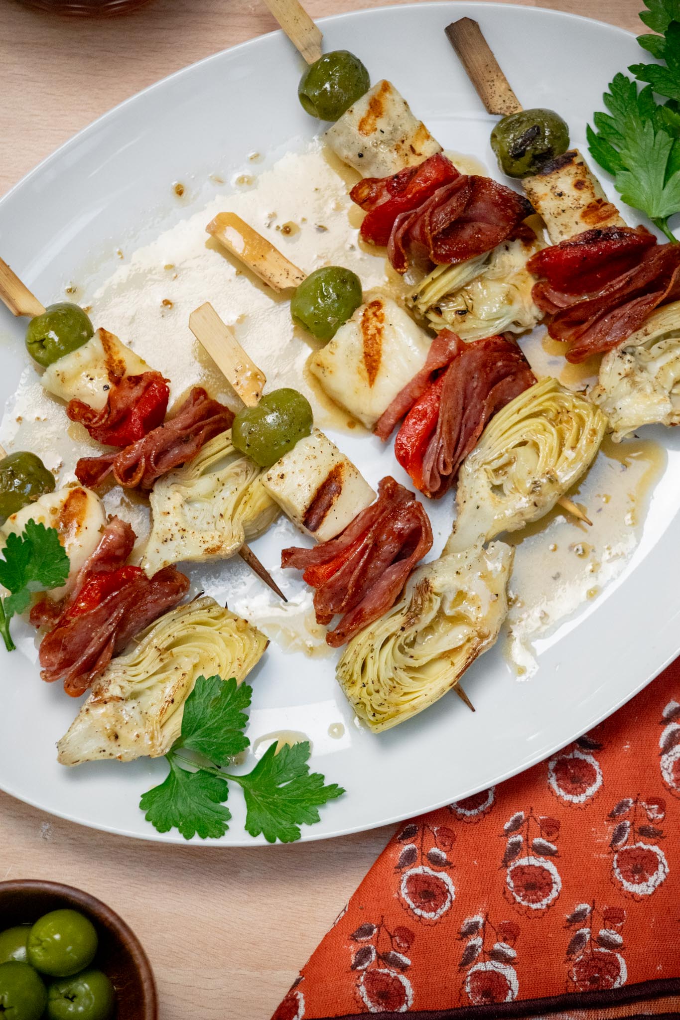 Plate of halloumi skewers drizzled with dressing. 