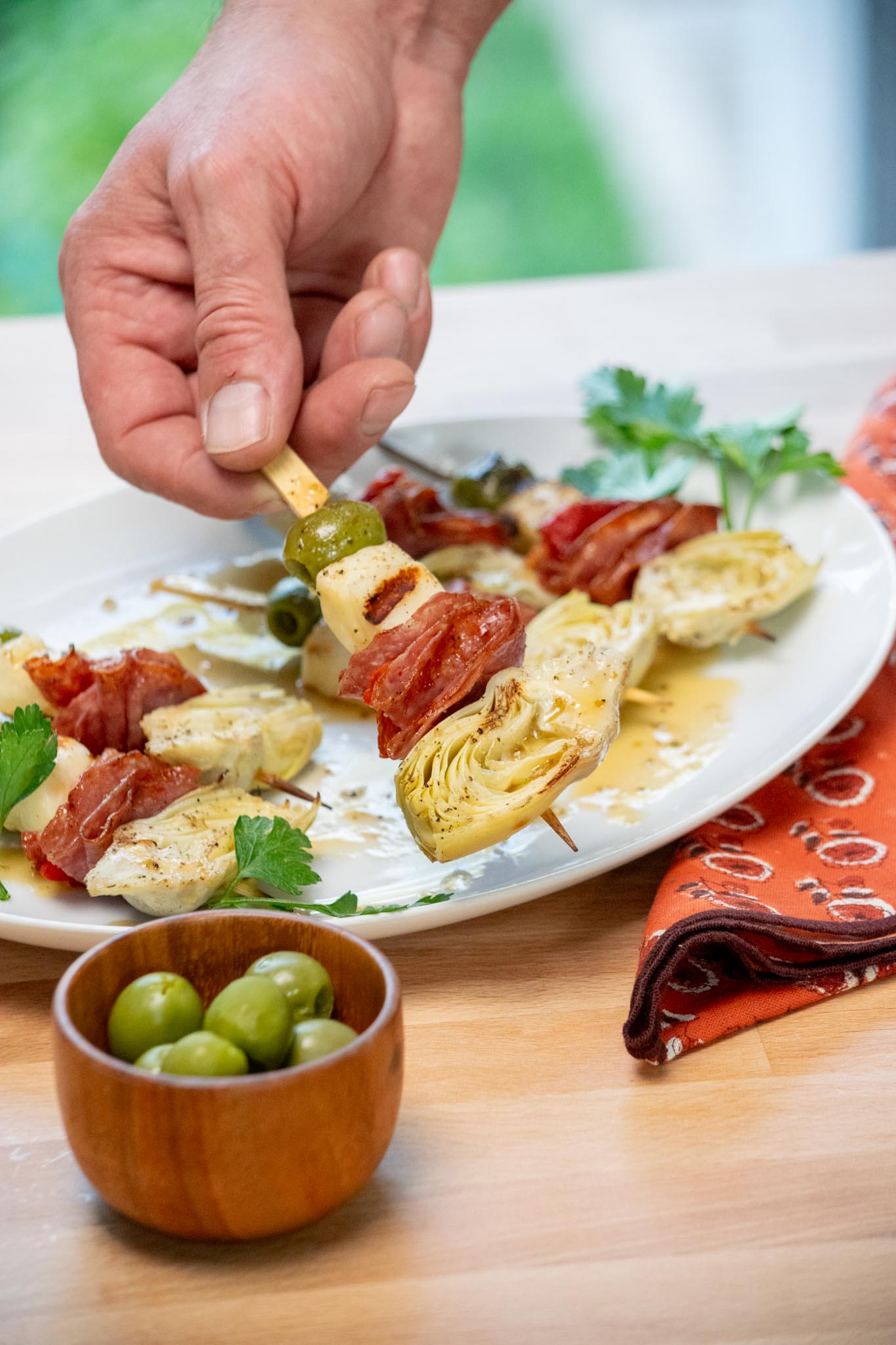 Picking up a halloumi skewer from a platter. 