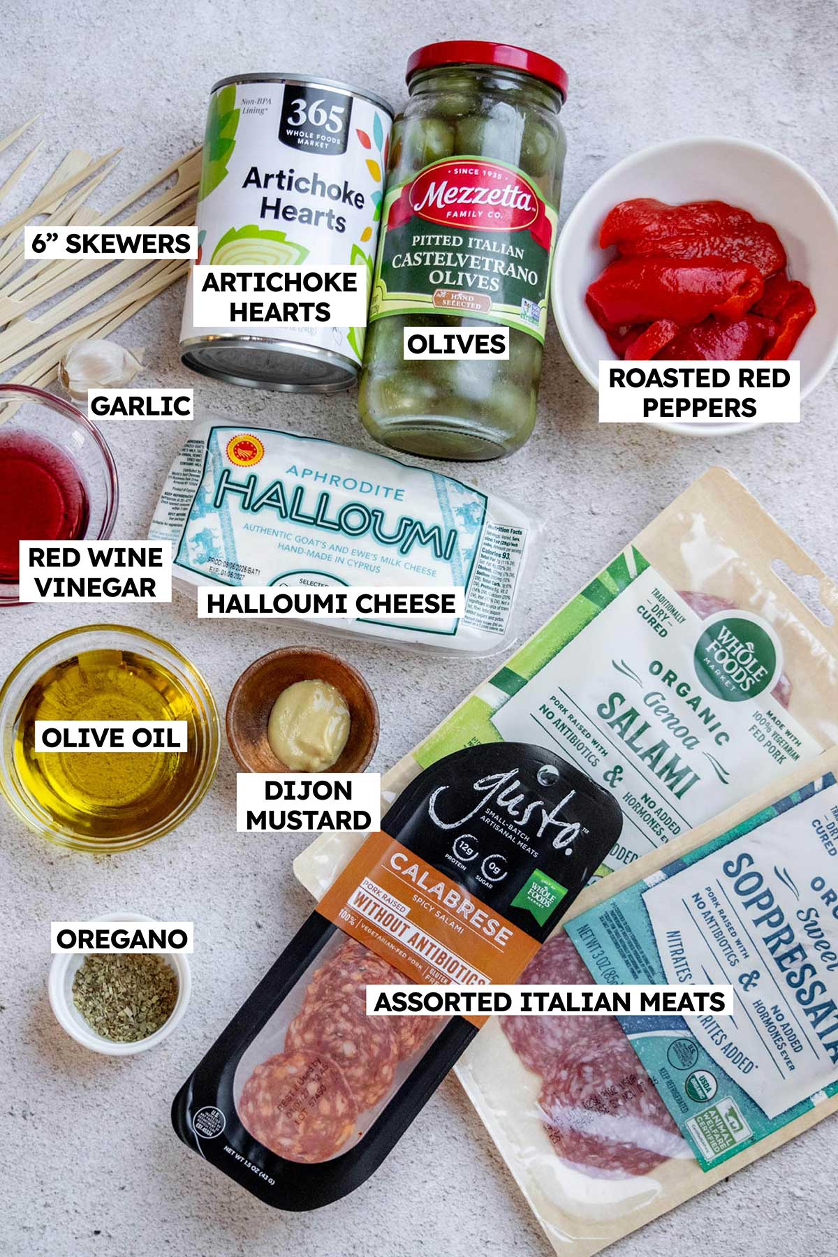 Halloumi Skewers Ingredients - red peppers, olives, Italian meats, halloumi, garlic, olive oil, red wine vinegar, dijon, oregano, artichoke hearts.