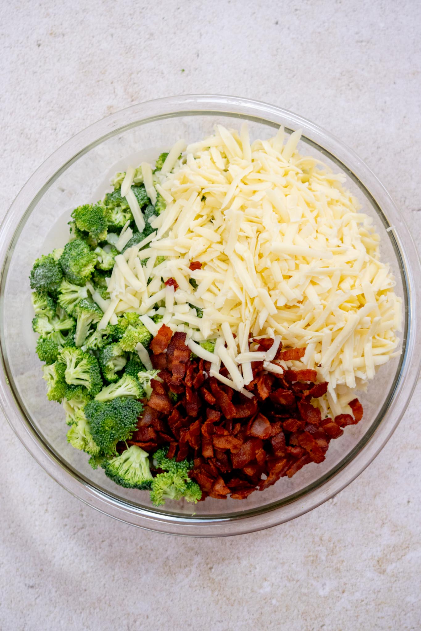 Add the drained crisp bacon, shredded cheddar, broccoli, and dressing to a large bowl. 