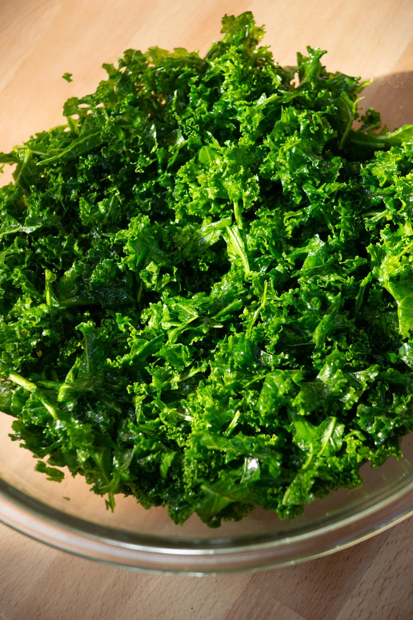 Drizzle a bit of olive oil onto the kale, and season with salt and pepper. Massage with your hands until bright green and reduced in size, about 1-2 minutes.