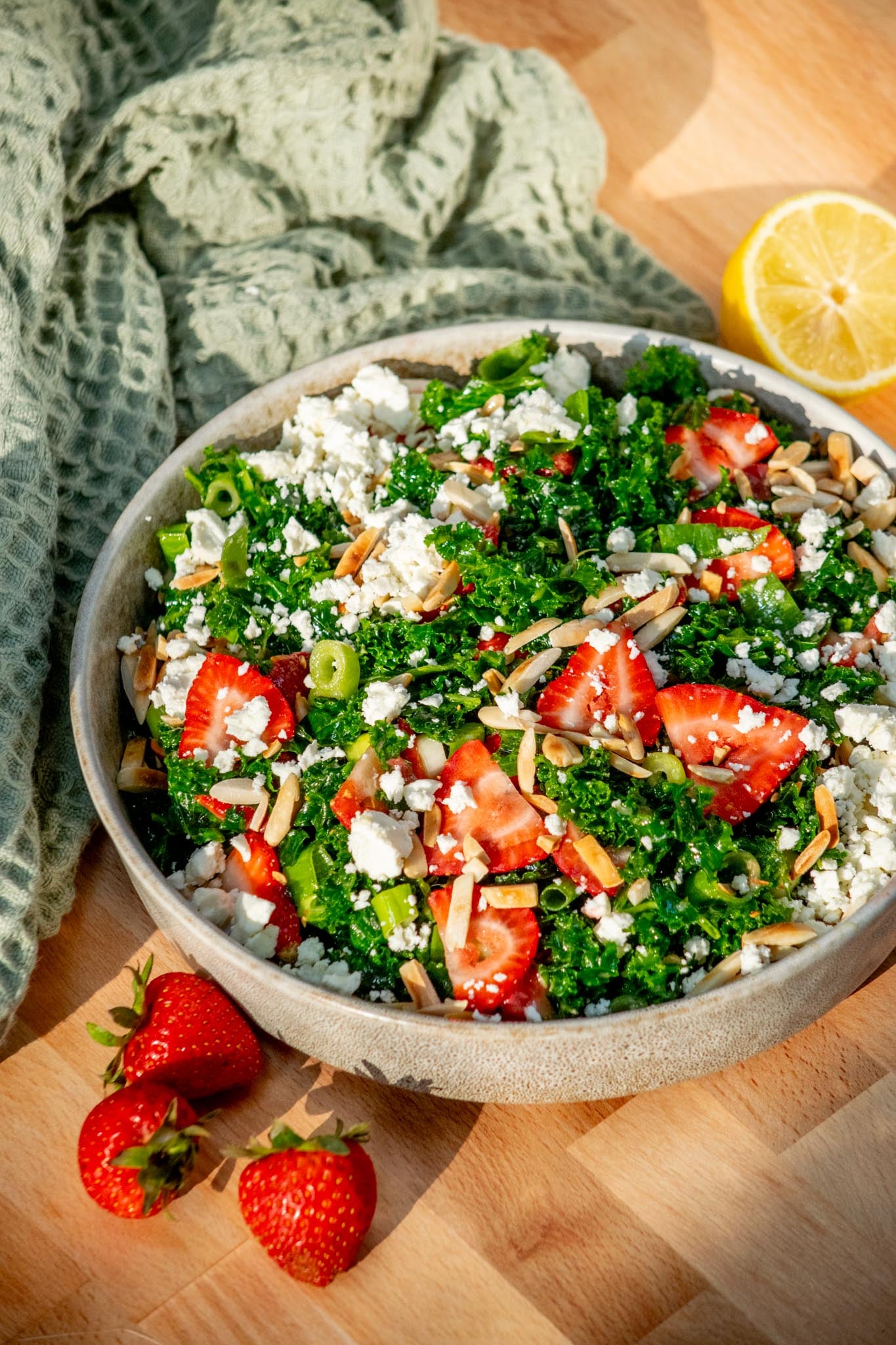 Easy Kale Salad with Strawberries and Feta in a eerving bowl.
