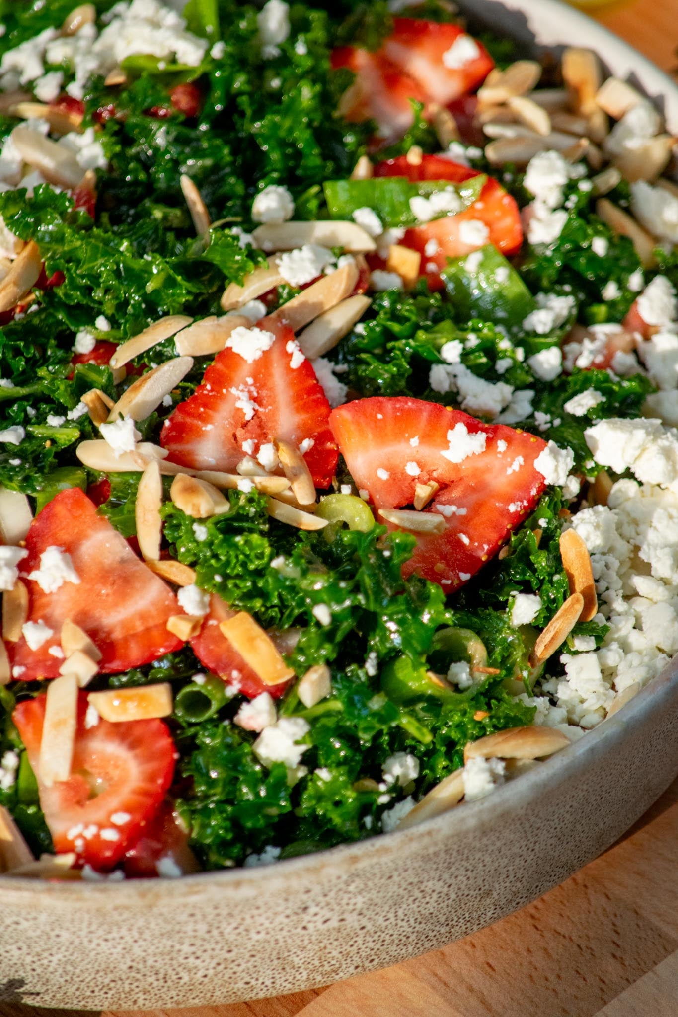 closeup detail of Easy Kale Salad with Strawberries and Feta in a serving bowl.