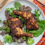 Air Fryer Chicken Leg Quarters on. a plate with greens.