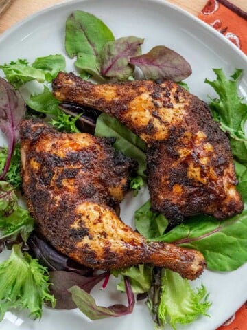 Air Fryer Chicken Leg Quarters on. a plate with greens.