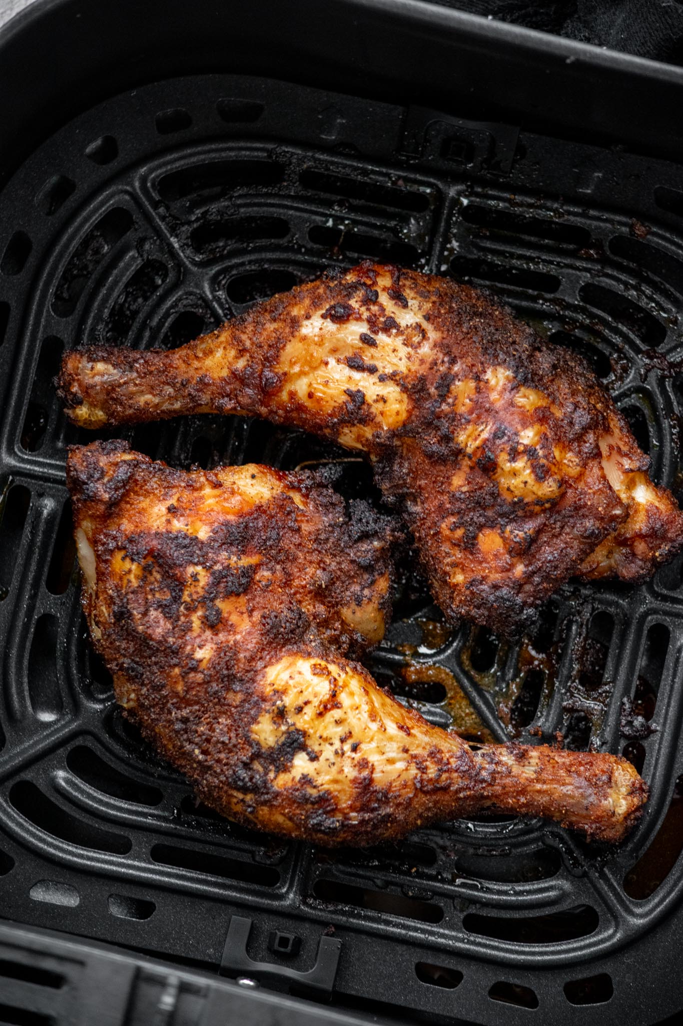 Air Fryer Chicken Leg Quarters in air fryer basket.