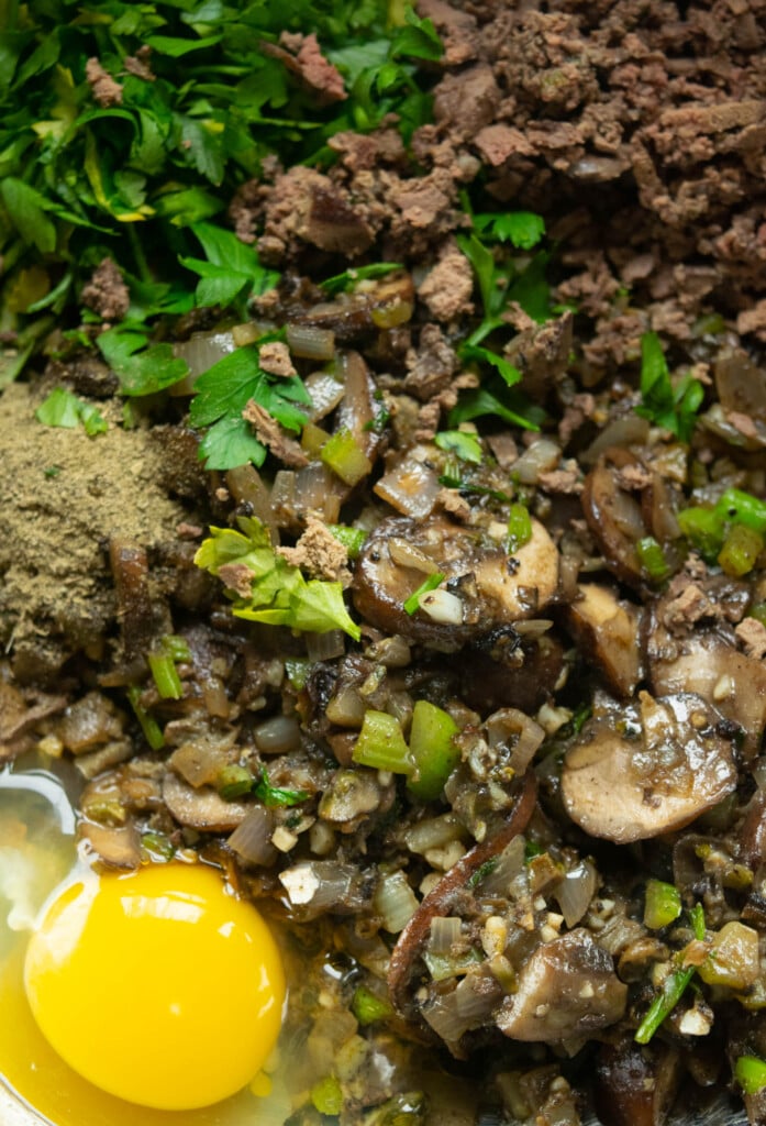 Toast your bread and set aside. Cook the aromatics and livers, finely mince the livers when cool enough to handle, add the stock, beaten egg, poultry seasoning, and parsley to a large bowl.