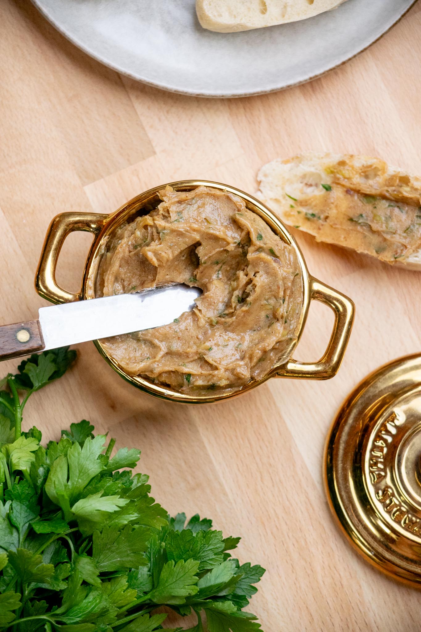 Spreading anchovy butter on crusty bread.