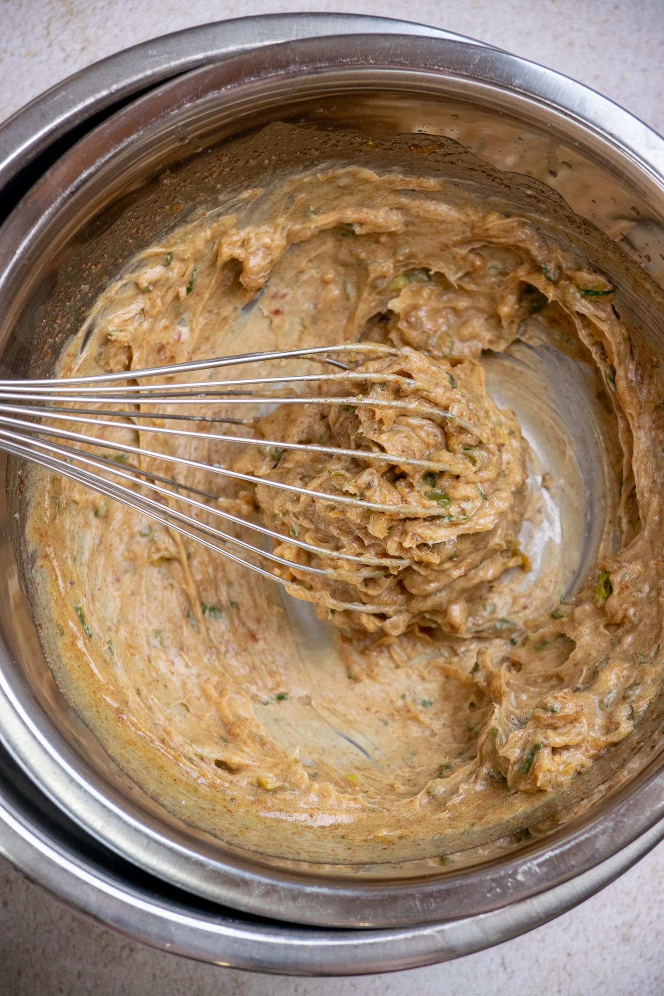 Transfer the mixture to a bowl set over another bowl filled with ice, and whisk continuously until the butter cools, and thickens-about 3–5 minutes.