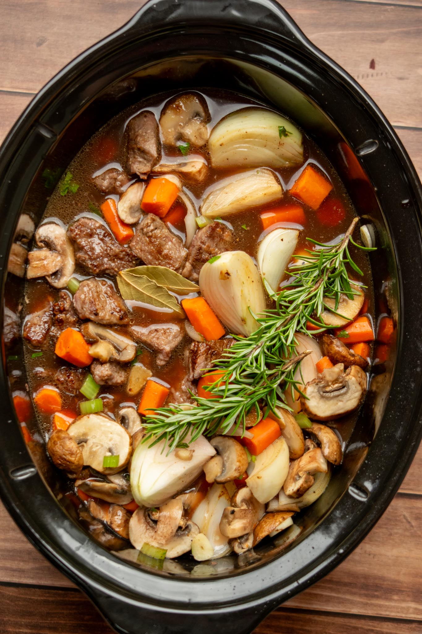 Add the broth and seasonings. Pour in the beef stock, red wine, Worcestershire sauce, and Kitchen Bouquet. Add the fresh rosemary and bay leaves. Cover and cook on LOW for 6–8 hours or HIGH for 4–5 hours, until the beef breaks apart easily with a spoon and the potatoes are tender.