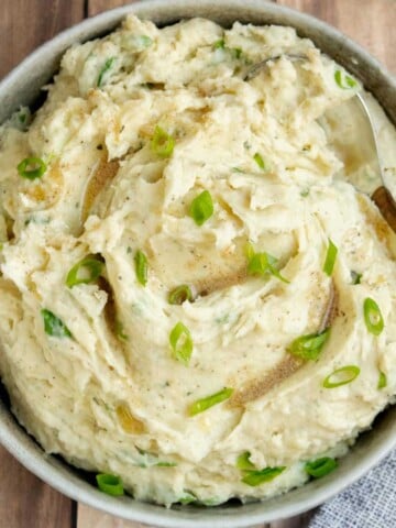 Creamy Boursin mashed potatoes with swirls of nutty browned butter, fresh scallions, and a rustic, fluffy texture.