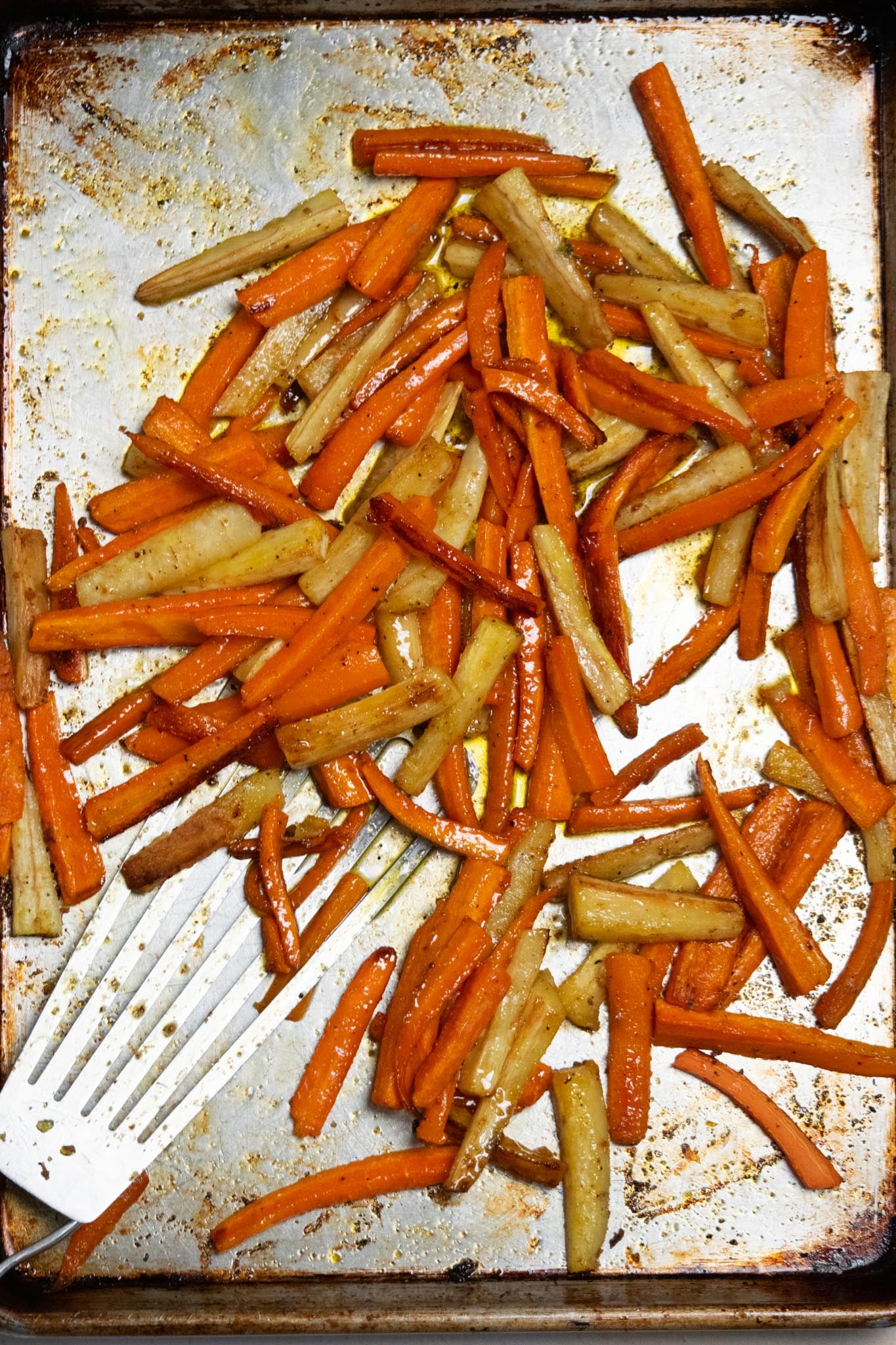 Glaze the vegetables. Toss the hot roasted carrots and parsnips with the warm honey thyme butter until evenly coated.