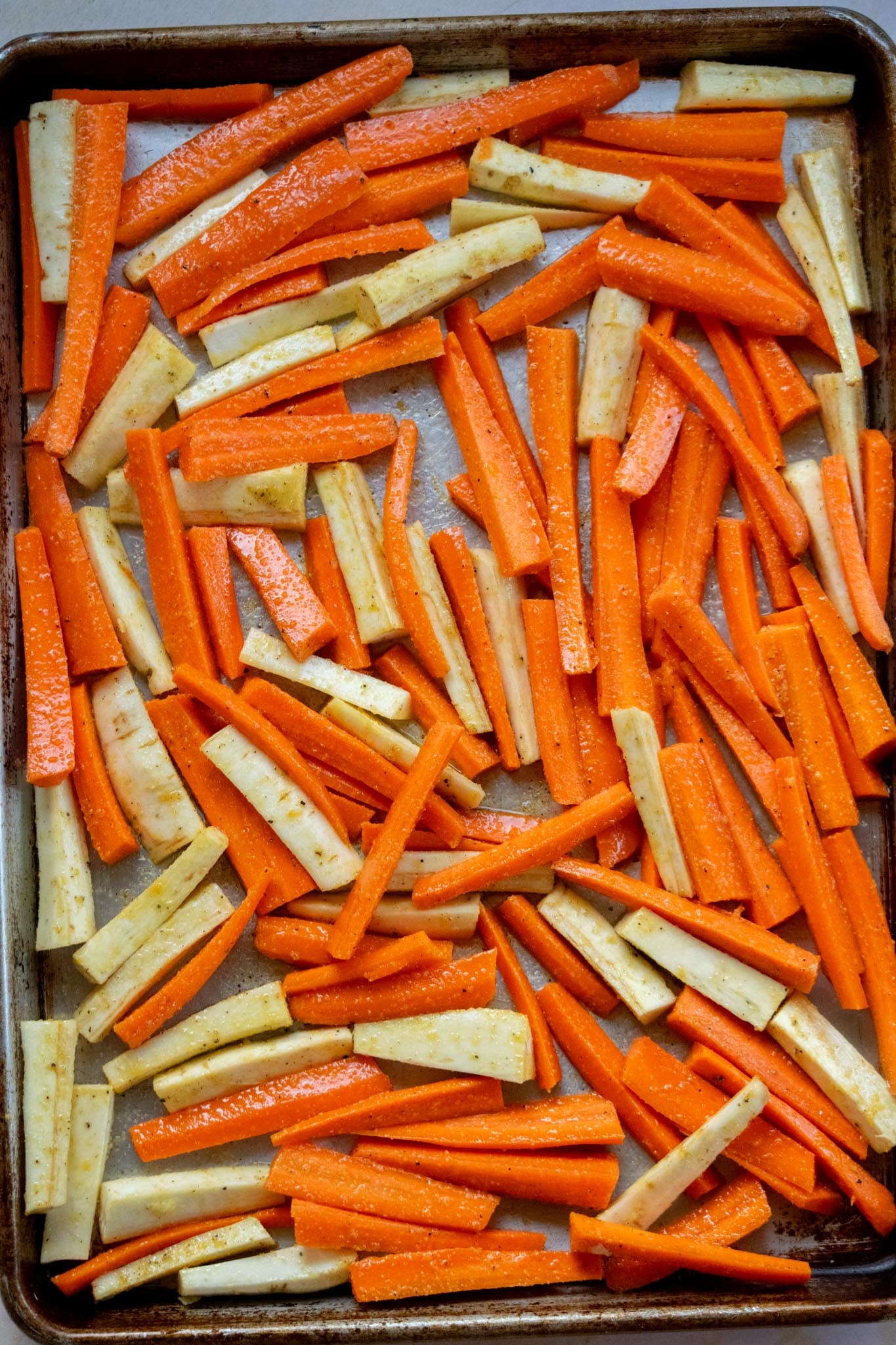 Season and roast. Toss the carrots and parsnips with olive oil, garlic powder, onion powder, salt, and pepper. Spread them out in a single layer on a baking sheet and roast until tender with caramelized edges.