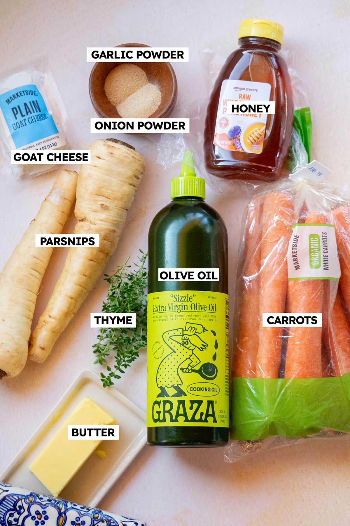 Ingredients for honey roasted parsnips and carrots, including carrots, parsnips, honey, butter, olive oil, goat cheese, fresh thyme, garlic powder, and onion powder.