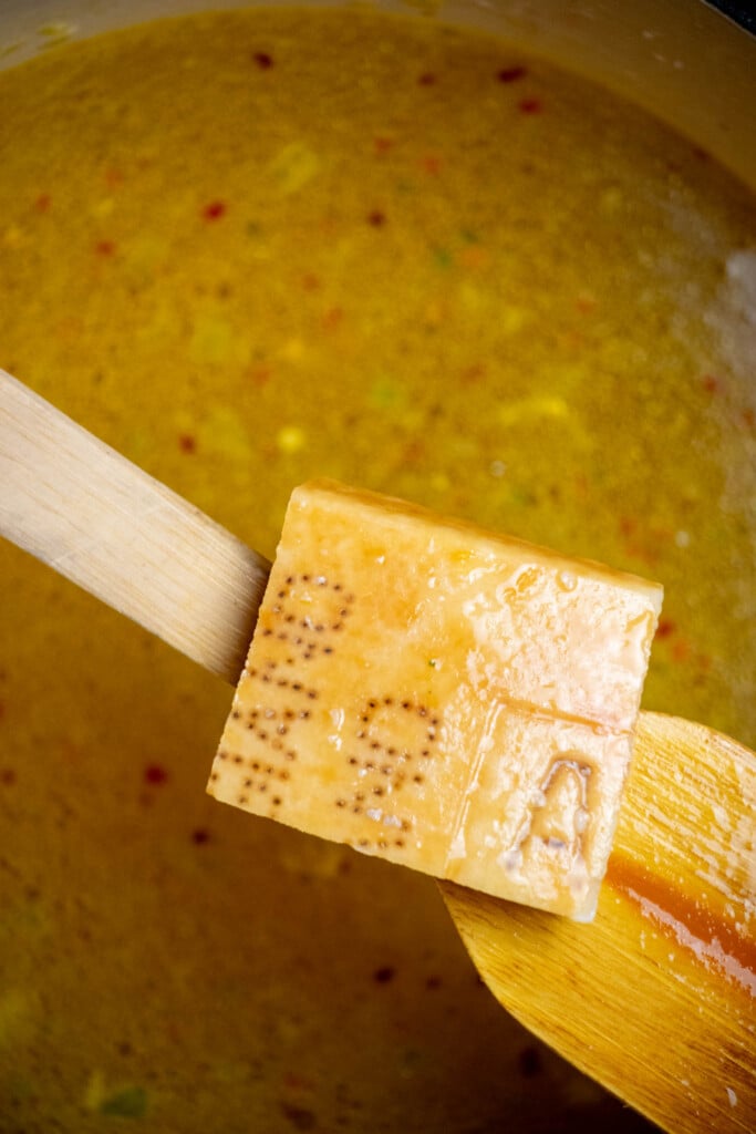 add chicken broth, bouillon, and parmesan rind. Bring to a boil over high heat. 